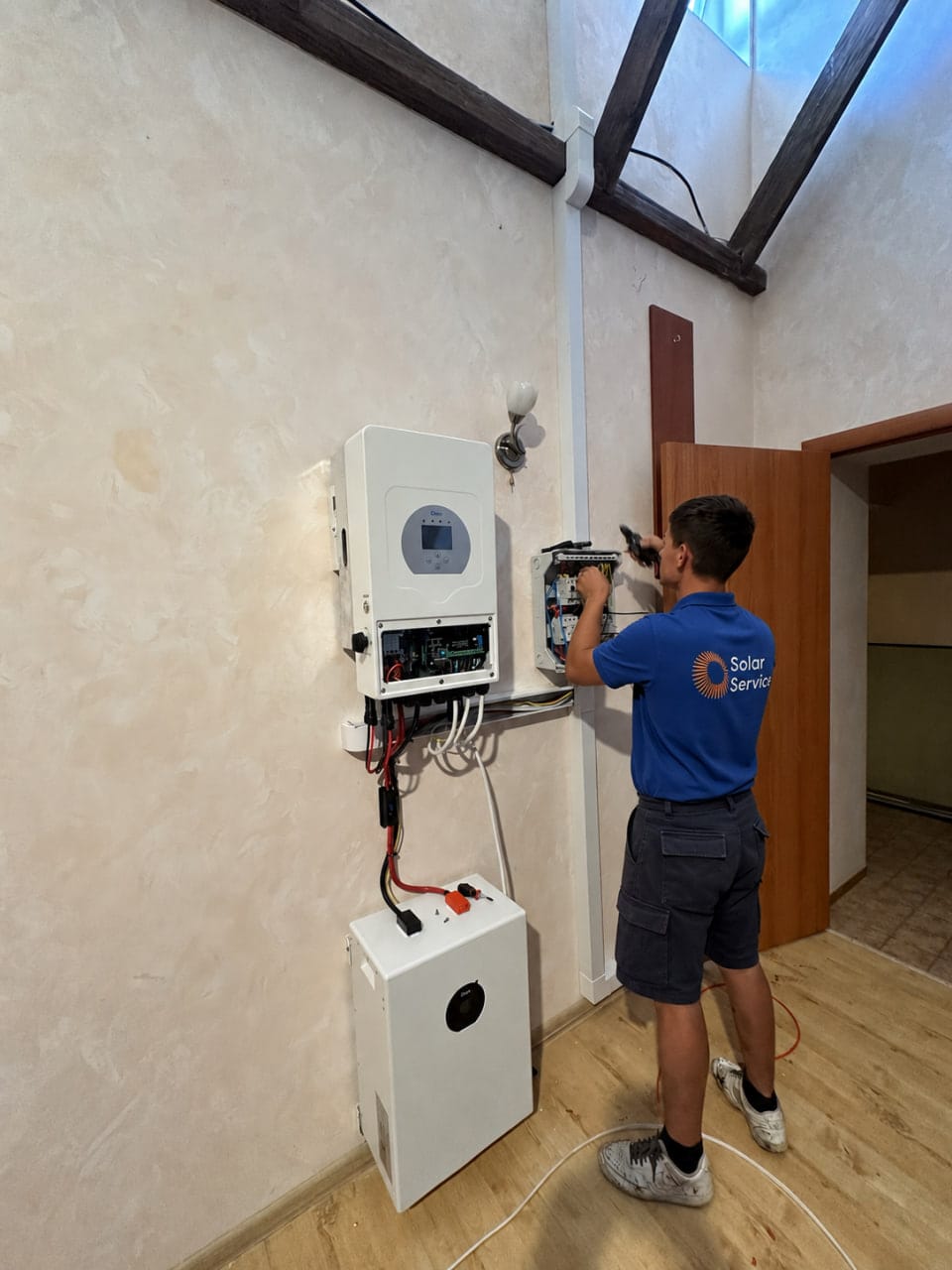 Інженер SolarService підключає інвертор і акумулятор до щита у квартирі